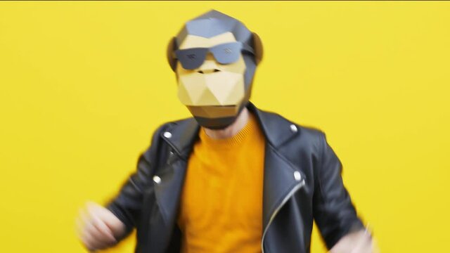 Man wearing funny masks and doing party. Celebrating and dancing over colored backgrounds