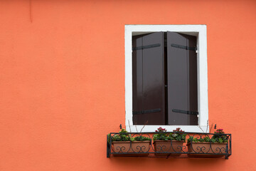 window shutters closed on orange wall, Burano, Venice