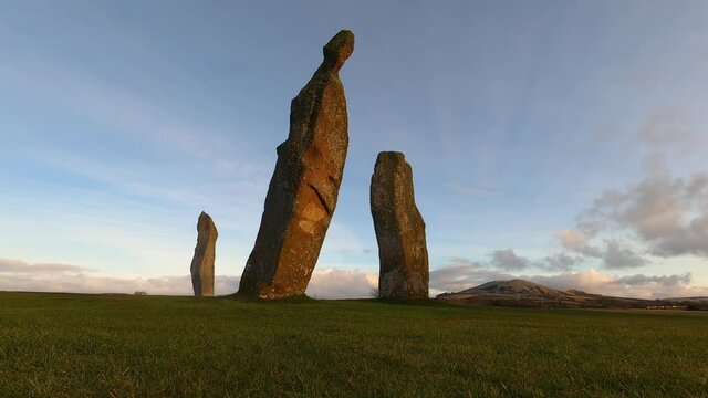 Ancient standing stones at Lundin Links, EAst Neuk of Fife, Scotland. 4k time lapse footage of sunrise with lots of sunlight and cloud movement with dramatic trio of standing stones in foreground.