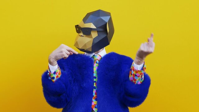 Man wearing funny masks and doing party. Celebrating and dancing over colored backgrounds