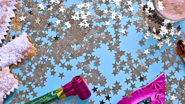 Falling confetti and sparkles fall. Traditional Venetian carnival and food TYPICAL. Coffee, Sfrappole or chiachiere or angel wings and aromatic coffee on a bright blue background. Copy space