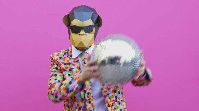 Man wearing funny masks and doing party. Celebrating and dancing over colored backgrounds