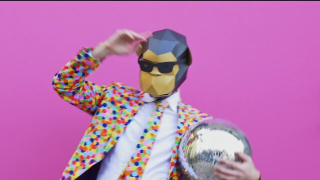 Man wearing funny masks and doing party. Celebrating and dancing over colored backgrounds