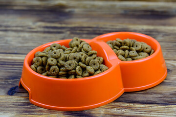 Bowl with pet food on a wooden background