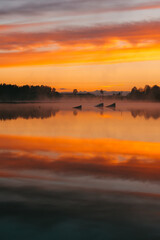 Colorful sunset over the Lielais Ansis lake in Latvia. Sunset reflections in the water over the...