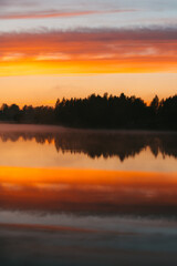 Colorful sunset over the Lielais Ansis lake in Latvia. Sunset reflections in the water