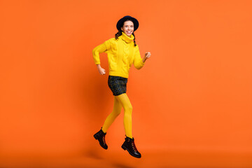 Fototapeta na wymiar Full length body size view of attractive skinny cheerful girl jumping running action isolated over bright orange color background