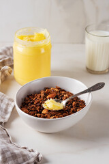 Homemade chocolate granola with ghee and milk on a light background. Healthy breakfast