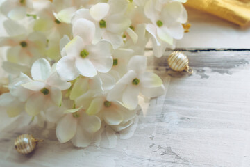 hydrangea blooms with golden beads on wooden bg
