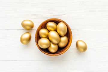 Golden Easter eggs in wooden bowl. Wealth and good luck concept.
