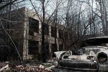 old rusty car on the background of a destroyed building