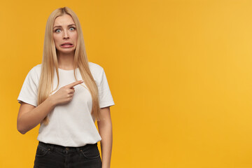 Teenage girl, unhappy looking woman with blond long hair. Wearing white t-shirt and black jeans....