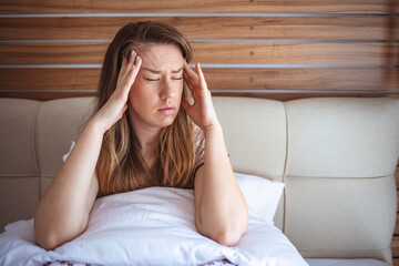 Sad woman suffering. Woman suffering from stress or a headache grimacing in pain. Woman pensive and...