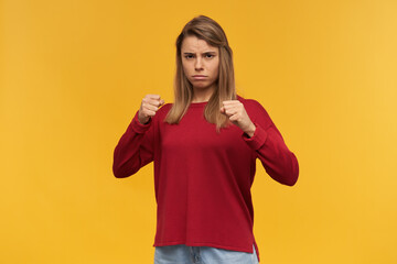 Girl with warlike look, showing her muscles, her power, stands in a fighting stance, holds his...