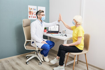 Senior woman thanks her attending audiologist after successfully treating her deafness at a hearing clinic