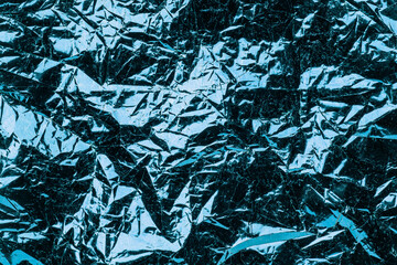 Turquoise background crumpled foil. textured metallic background