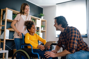 Happy multiethnic family with child with disability in wheelchair