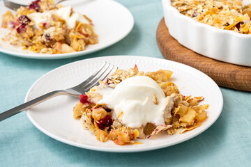 Apple and pear crumble with ice cream, streusel. Sweet dessert with stewed fruit topped crisp crumbly mixture served ice cream. Apple cobbler pie in baking dish on tablecloth. Top view