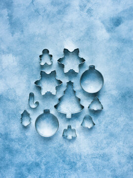 Metal cookie cutters of different shapes on blue background