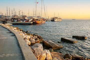Fototapeta na wymiar Stylish luxury yachts, ships and sailing boats moored on Bodrum Marina, Turkey, on the sunset.