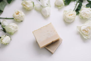 Handmade natural floral soap and roses on white background. Soap making. Soap bars. Spa, skin care. Natural Organic spa cosmetics on white table from above. flat lay, top view