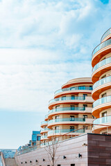 A multi-storey residential or business modern building with a rounded shape against the blue sky