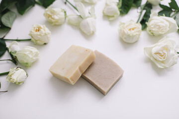 Handmade natural floral soap and roses on white background. Soap making. Soap bars. Spa, skin care. Natural Organic spa cosmetics on white table from above. flat lay, top view