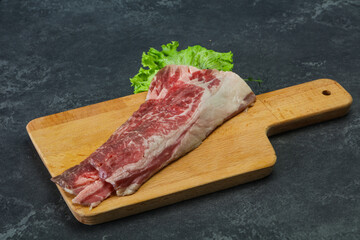 Raw beef bacon over wooden board