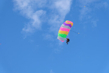 Skydiving. A parachute is in the blue sky.