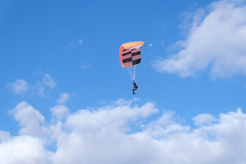 Skydiving. A parachute is in the blue sky.