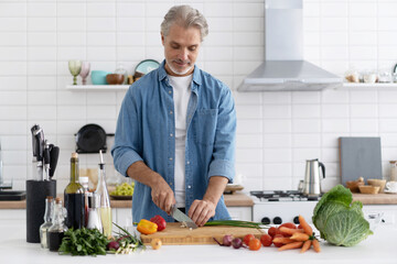 Happy handsome man cooking in kitchen at home