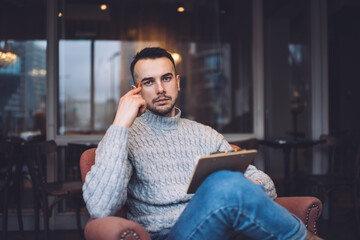 Serious man with clipboard in cafe