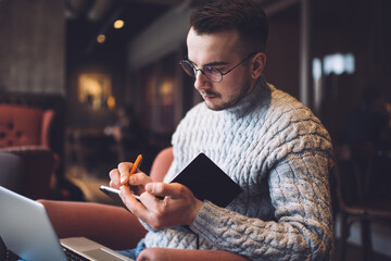 Concentrated man writing in notebook