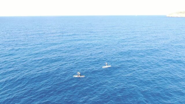 vista a&eacute;rea de tablas de paddle surf sobre las aguas de color azul turquesa sobre el mar de un playa de Mallorca. Concepto de vacaciones playa verano y diversion