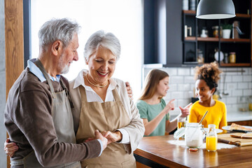 Affectionate senior grandparents in love with children in kitchen