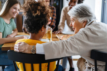 Multi generation and ethnic, diverse family dining together