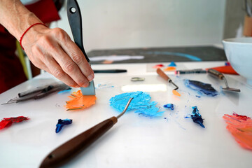 Detail of paint brushes and bright paint in an artist’s studio