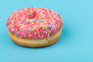 Fresh made Donuts isolated on blue background. Doughnuts are traditional sweet pastries. Copy space for text.