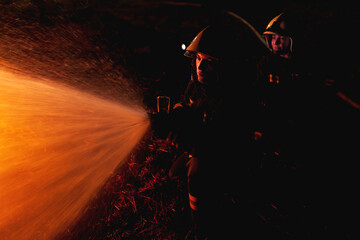 Obraz premium Professional firefighters puttion out a fire with water.