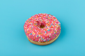 Fresh made Donuts isolated on blue background. Doughnuts are traditional sweet pastries. Copy space for text.