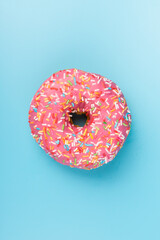 Fresh made Donuts isolated on blue background. Doughnuts are traditional sweet pastries. Copy space for text.