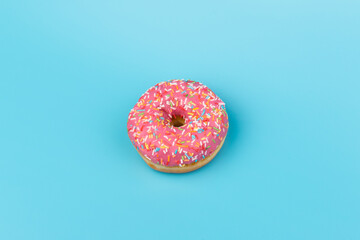 Fresh made Donuts isolated on blue background. Doughnuts are traditional sweet pastries. Copy space for text.