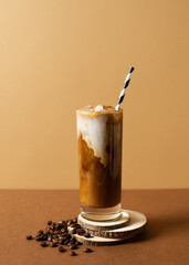 Ice coffee in tall glasses with milk and drinking straw on wooden podiun over brown background