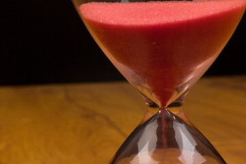 Crystal hourglass on wooden background as a concept of passing time for business term, urgency and...