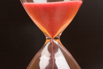Crystal hourglass on black background as a concept of passing time for business term, urgency and...