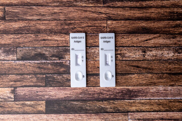 two Covid 19 antigen saliva tests with negative and positive result are on a structured background. Negative test result to participate in public life. Positive Test