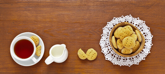 Homemade cookies on a lace napkin and a cup of tea on a wooden table. Place for the text of the recipe. Delicious pastries for Easter or Christmas. Flat lay, copy space, top view, mock up