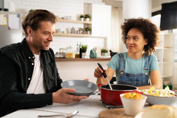 Loving couple eating lunch together at home. Husband and wife enjoying in tasty meal.