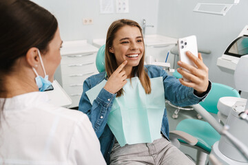 Happy young woman taking a selfie during medical checkup