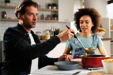 Loving couple eating lunch together at home. Husband and wife enjoying in tasty meal.
